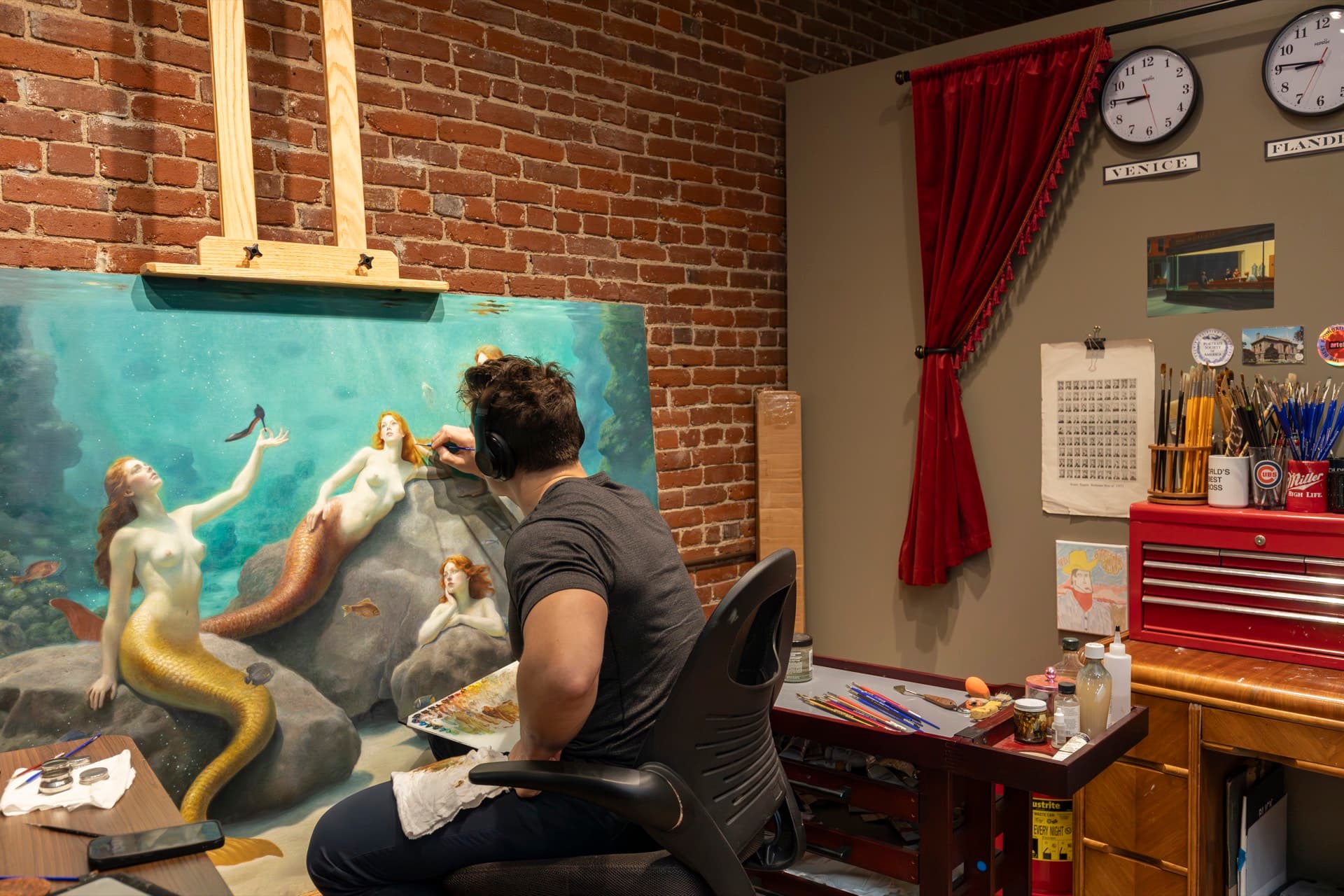 A painter at the easel working on a marine figure painting inside an Occidental third-floor studio.